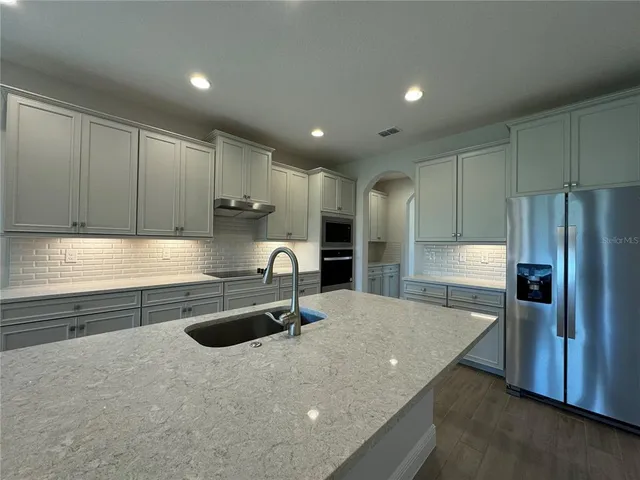 a kitchen with kitchen island a sink stainless steel appliances and cabinets