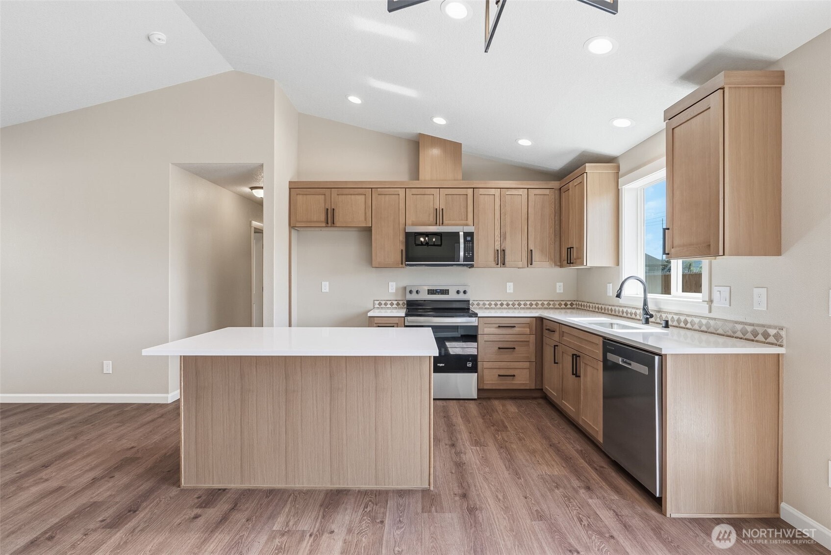 204 Douglas Street Longview, WA 98632 - Photo 20 of 31 a kitchen with stainless steel appliances granite countertop a stove top oven a sink a refrigerator and white cabinets with wooden floor