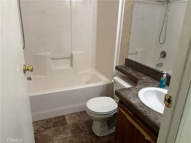 a bathroom with a granite countertop toilet sink and shower