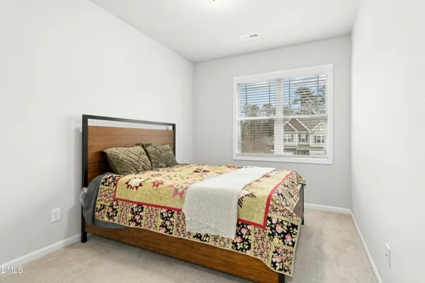 a bedroom with a bed next to a window