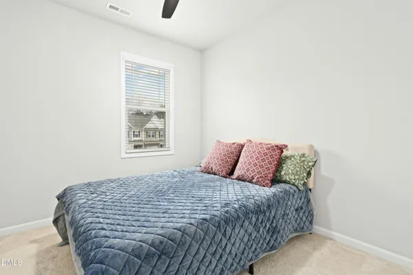 a large bed sitting in a bedroom next to a window