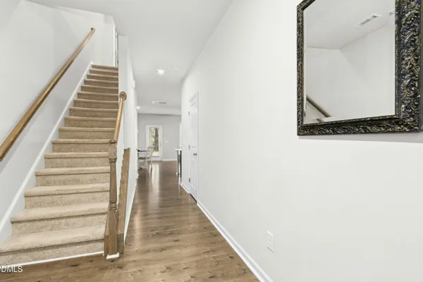 a view of a hallway with wooden floor and staircase