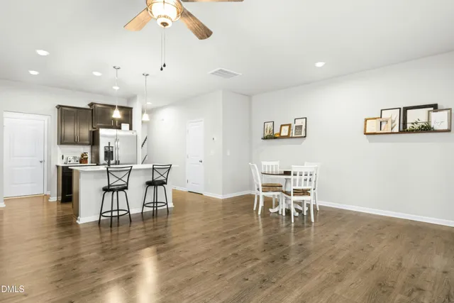 a dining room with wooden floor a glass table and chairs