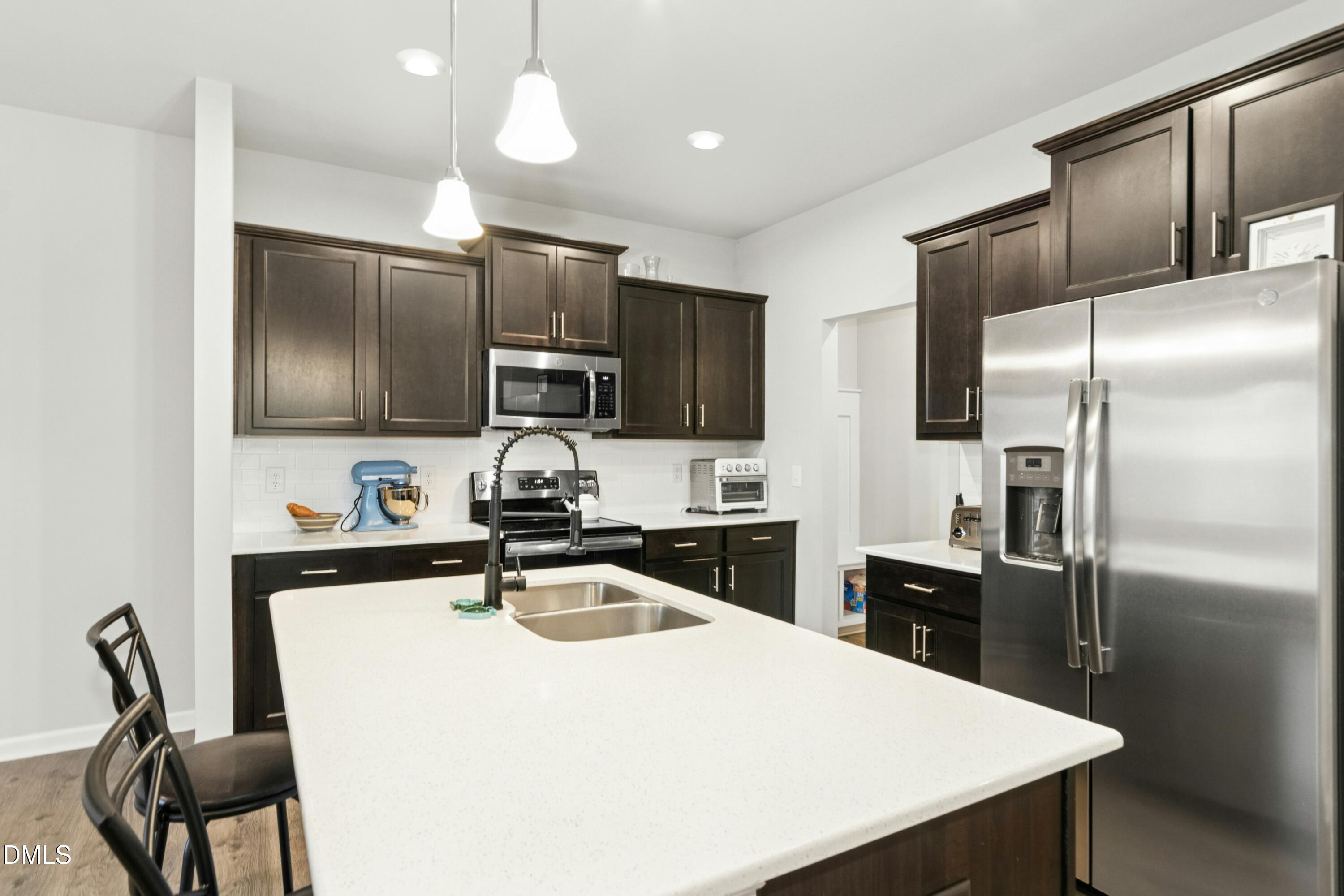 3645 Water Mist Lane Raleigh, NC 27604 - Photo 10 of 29 a kitchen with kitchen island a counter top space cabinets stainless steel appliances and wooden floor