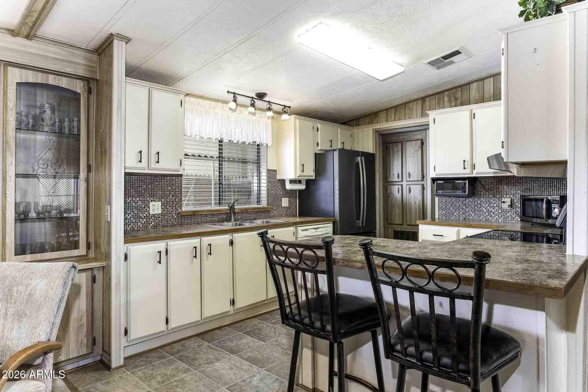 2100 North Trekell Road, Unit 143 Casa Grande, AZ 85122 - Photo 18 of 34 a kitchen with stainless steel appliances granite countertop a stove a refrigerator a kitchen island and chairs