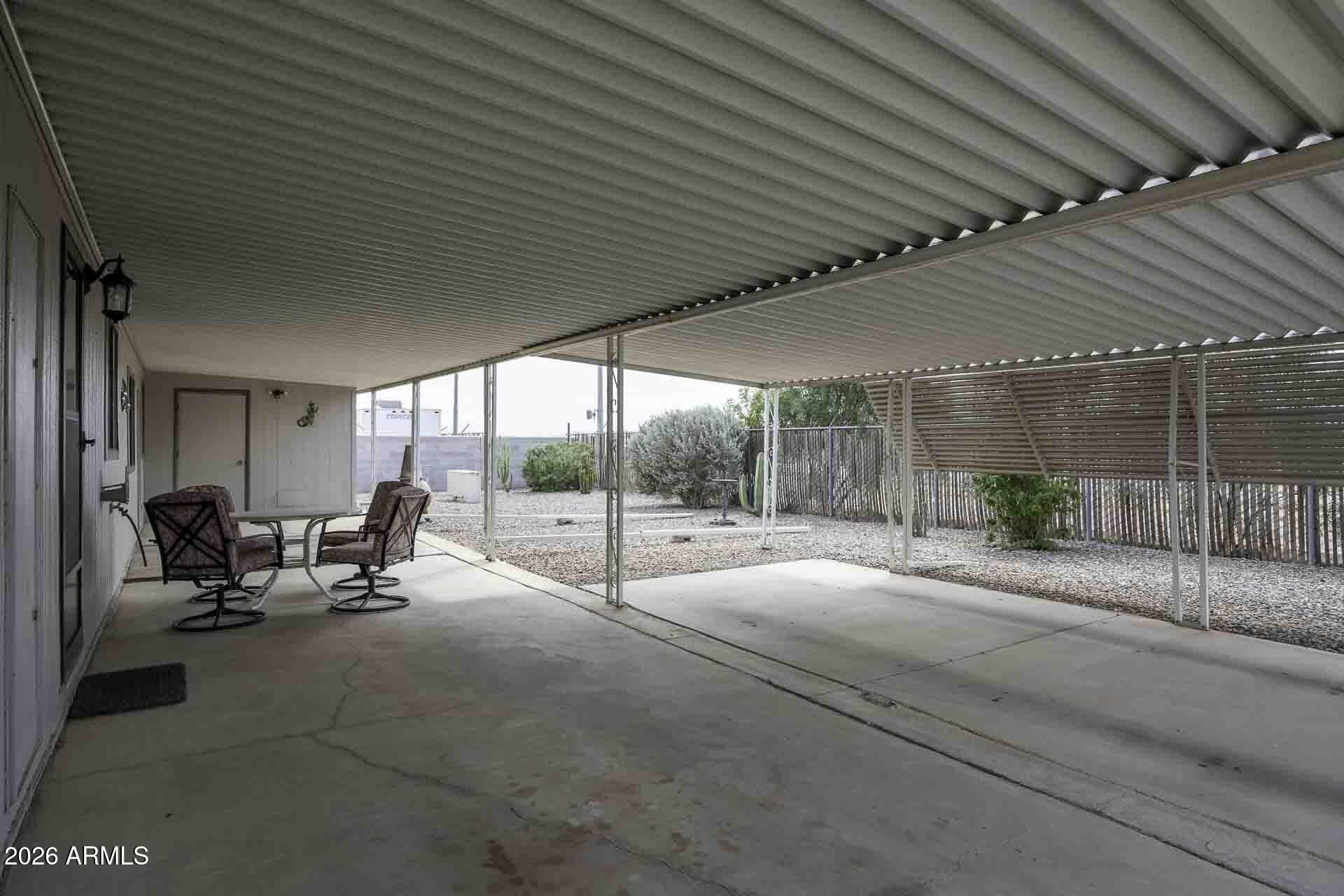 2100 North Trekell Road, Unit 143 Casa Grande, AZ 85122 - Photo 26 of 34 a view of a patio with table and chairs and floor to ceiling window