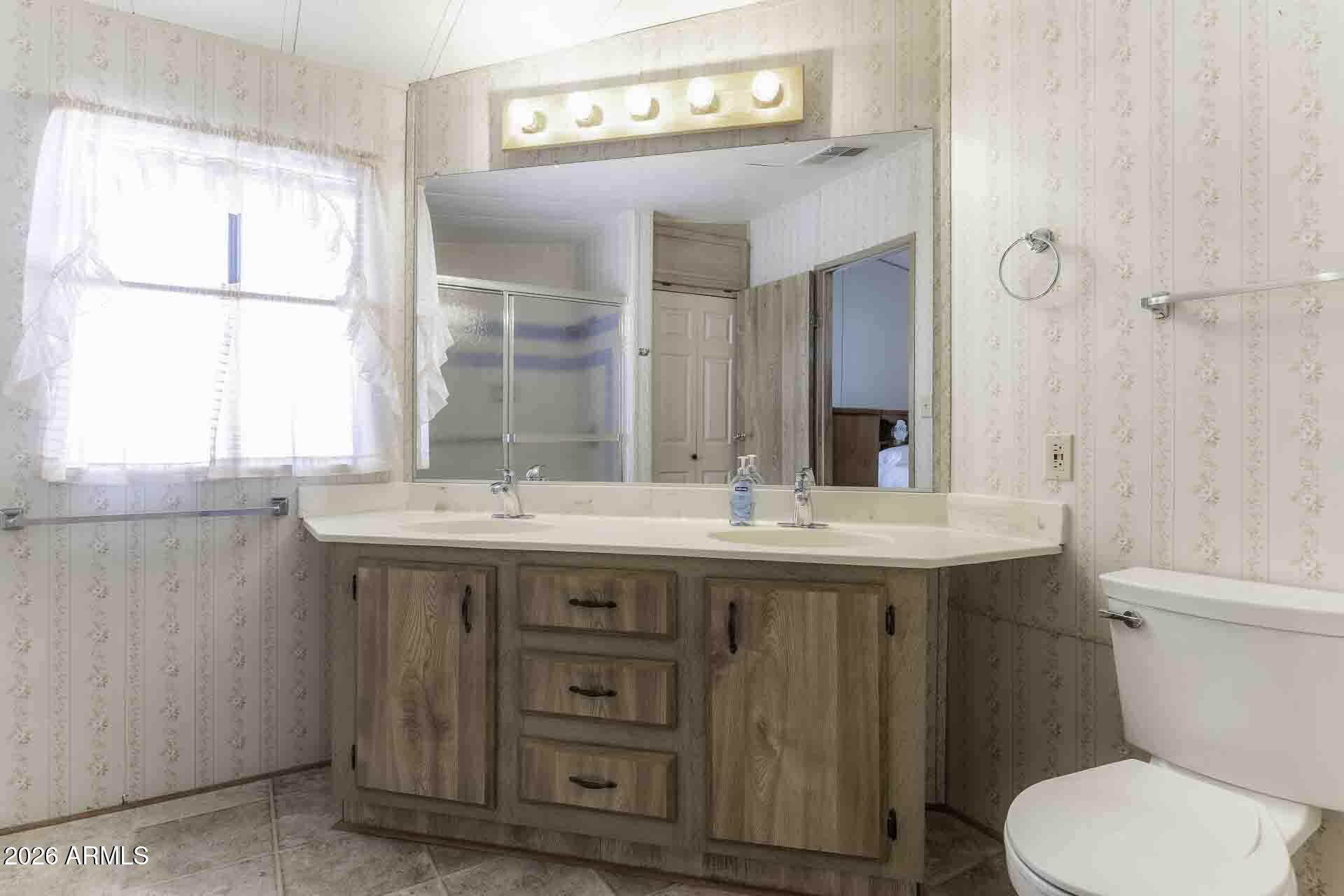 2100 North Trekell Road, Unit 143 Casa Grande, AZ 85122 - Photo 28 of 34 a bathroom with a granite countertop toilet a sink and a window