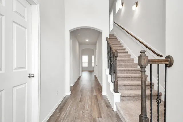 a view of a hallway with wooden floor and staircase