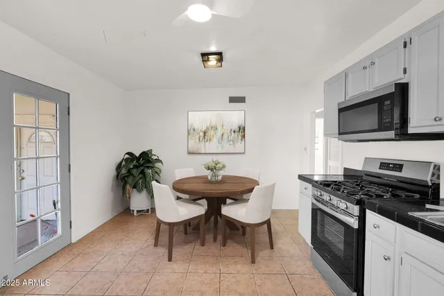 a kitchen with stainless steel appliances a stove a sink cabinets and a dining table