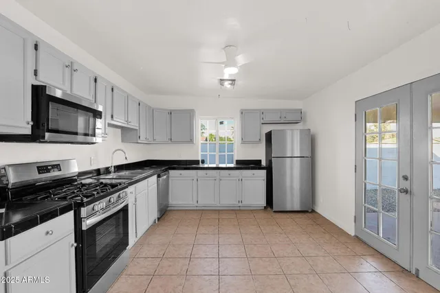 a kitchen with granite countertop a refrigerator and a stove top oven