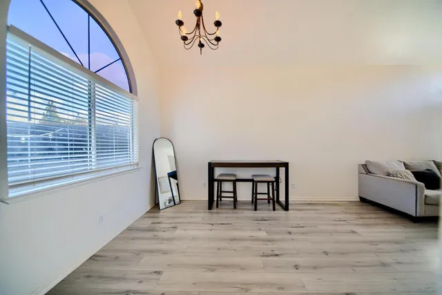 a view of a kitchen with kitchen island a sink wooden floor and a large window