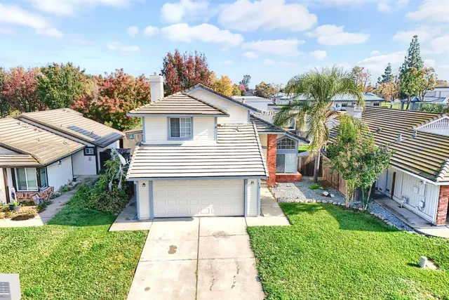 a front view of a house with a yard and potted plants
