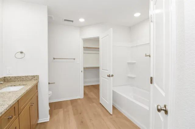 a bathroom with a granite countertop sink a toilet and bathtub