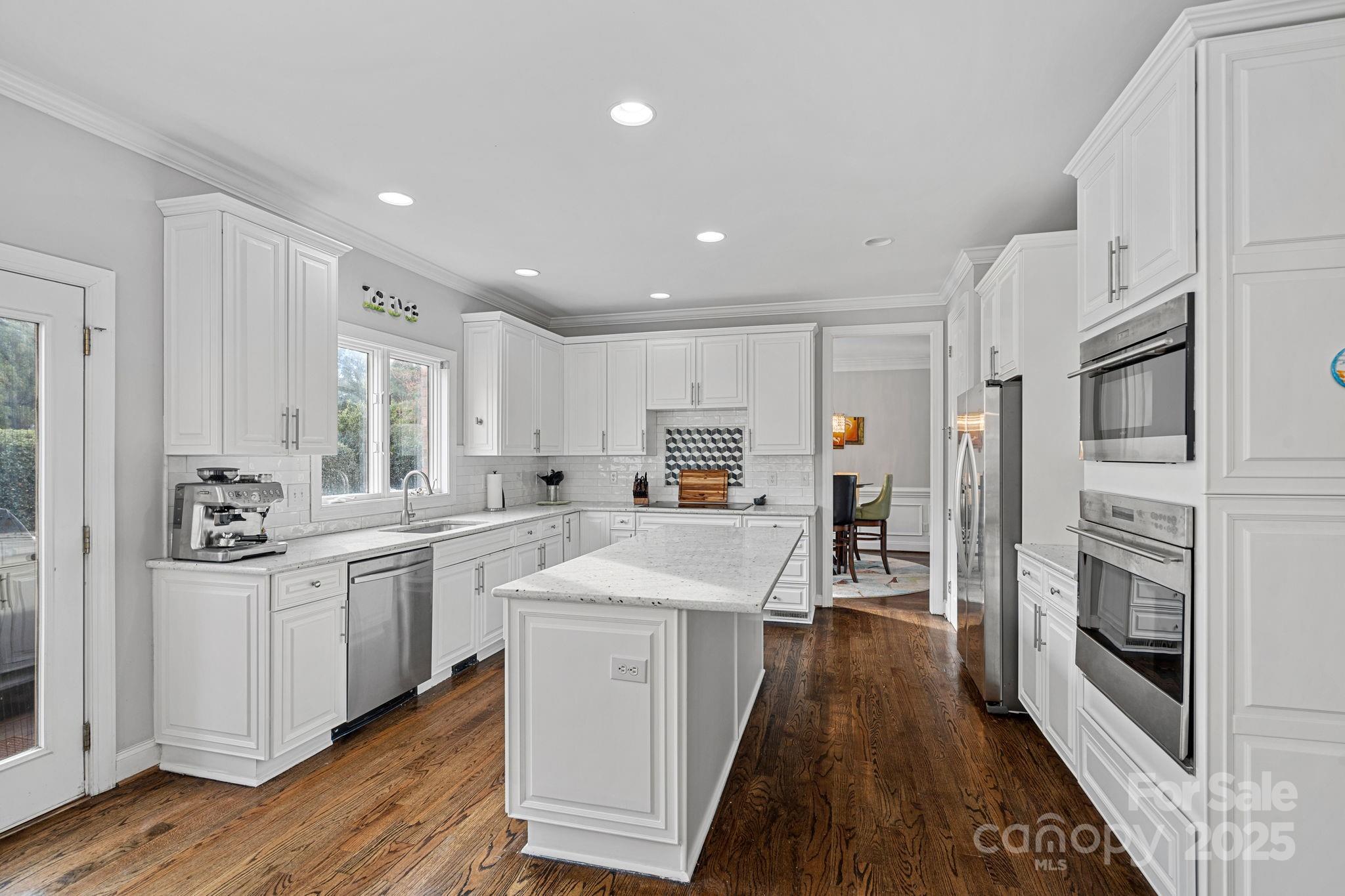 18334 Dembridge Drive Davidson, NC 28036 - Photo 12 of 35 a kitchen with stainless steel appliances kitchen island granite countertop a stove and a refrigerator