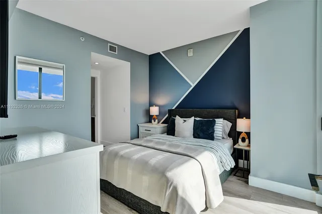 a bedroom with a large bed and a large window