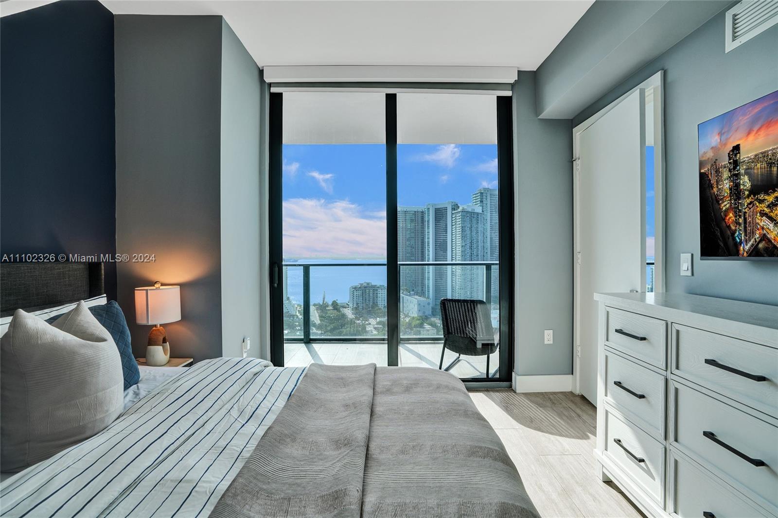 121 Northeast 34th Street, Unit 2906 Miami, FL 33137 - Photo 22 of 65 a view of a bedroom with a large bed and tv