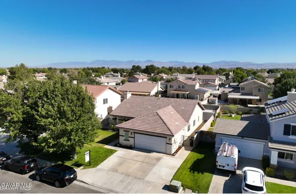 an aerial view of residential houses with outdoor space and trees