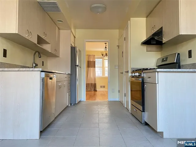a kitchen with a refrigerator and a stove top oven