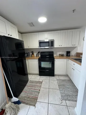 a kitchen with a sink a microwave and cabinets