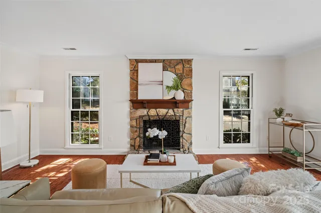 a living room with furniture fireplace and a window