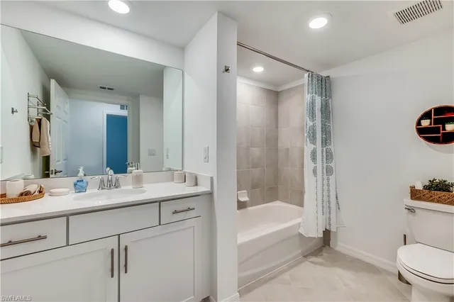 a bathroom with a bathtub shower sink vanity and toilet