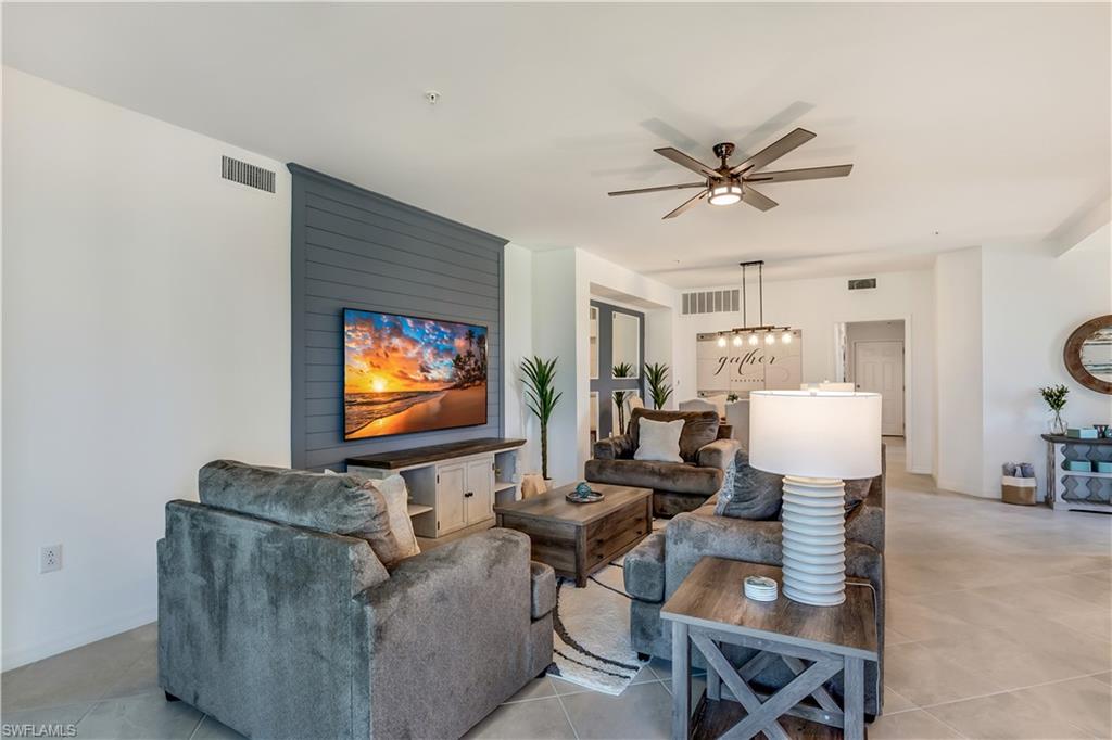 43330 Water Bird Way, Unit 6911 Punta Gorda, FL 33982 - Photo 8 of 17 Living room featuring tile flooring and ceiling fan with notable chandelier