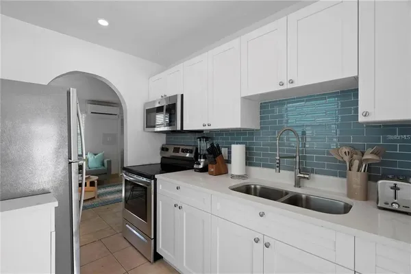 a kitchen with stainless steel appliances kitchen island a refrigerator a stove a sink dishwasher and a stove with wooden floor