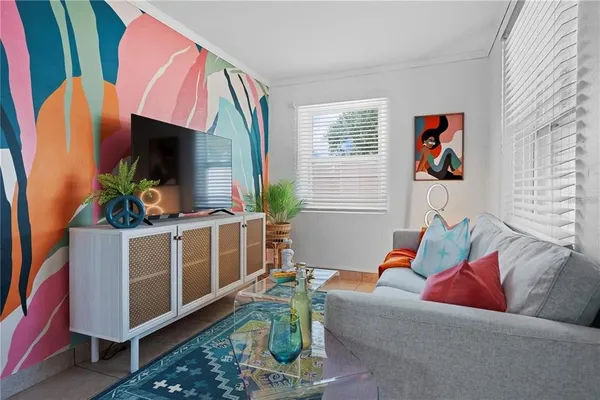 a living room with furniture a flat screen tv and a window