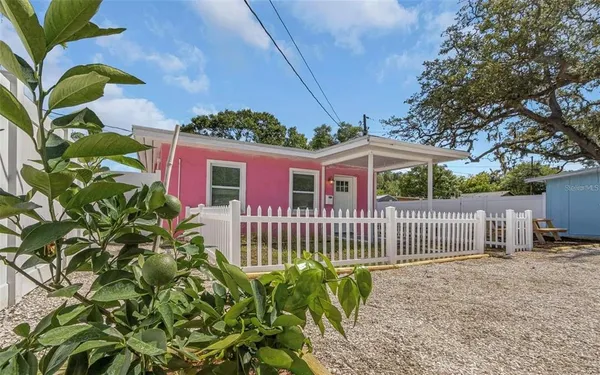a view of a house with a small yard and wooden fence
