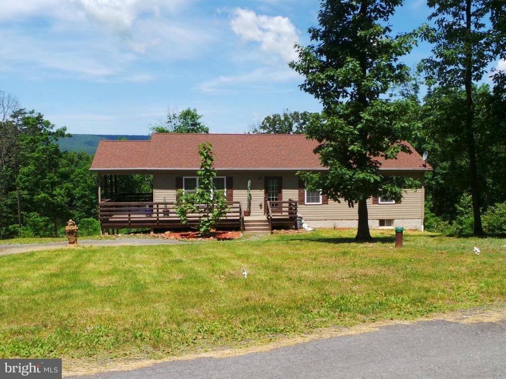 4258 Timber Ridge Road Berkeley Springs, WV 25411 - Photo 23 of 26 a view of a swimming pool with a table and chairs under an umbrella