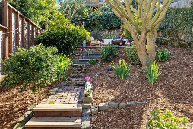 a view of a backyard with furniture and a garden