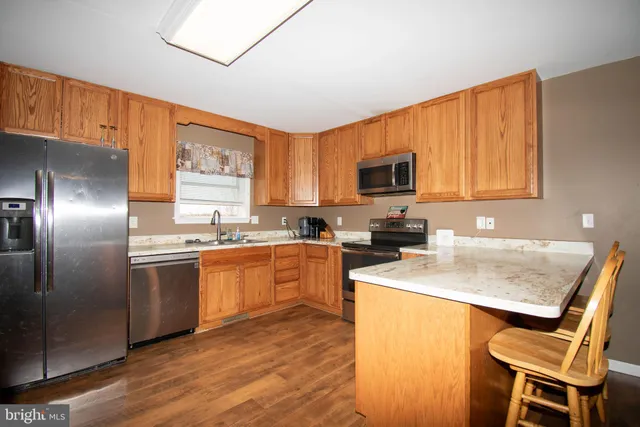 a kitchen with stainless steel appliances granite countertop a stove refrigerator sink and microwave