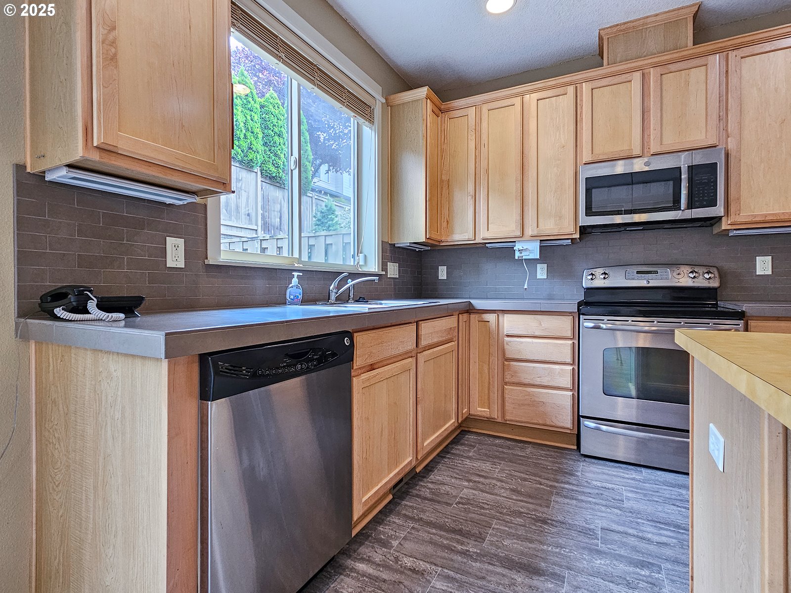 15621 Southeast Eckert Lane Damascus, OR 97089 - Photo 12 of 24 a kitchen with stainless steel appliances a stove sink and microwave