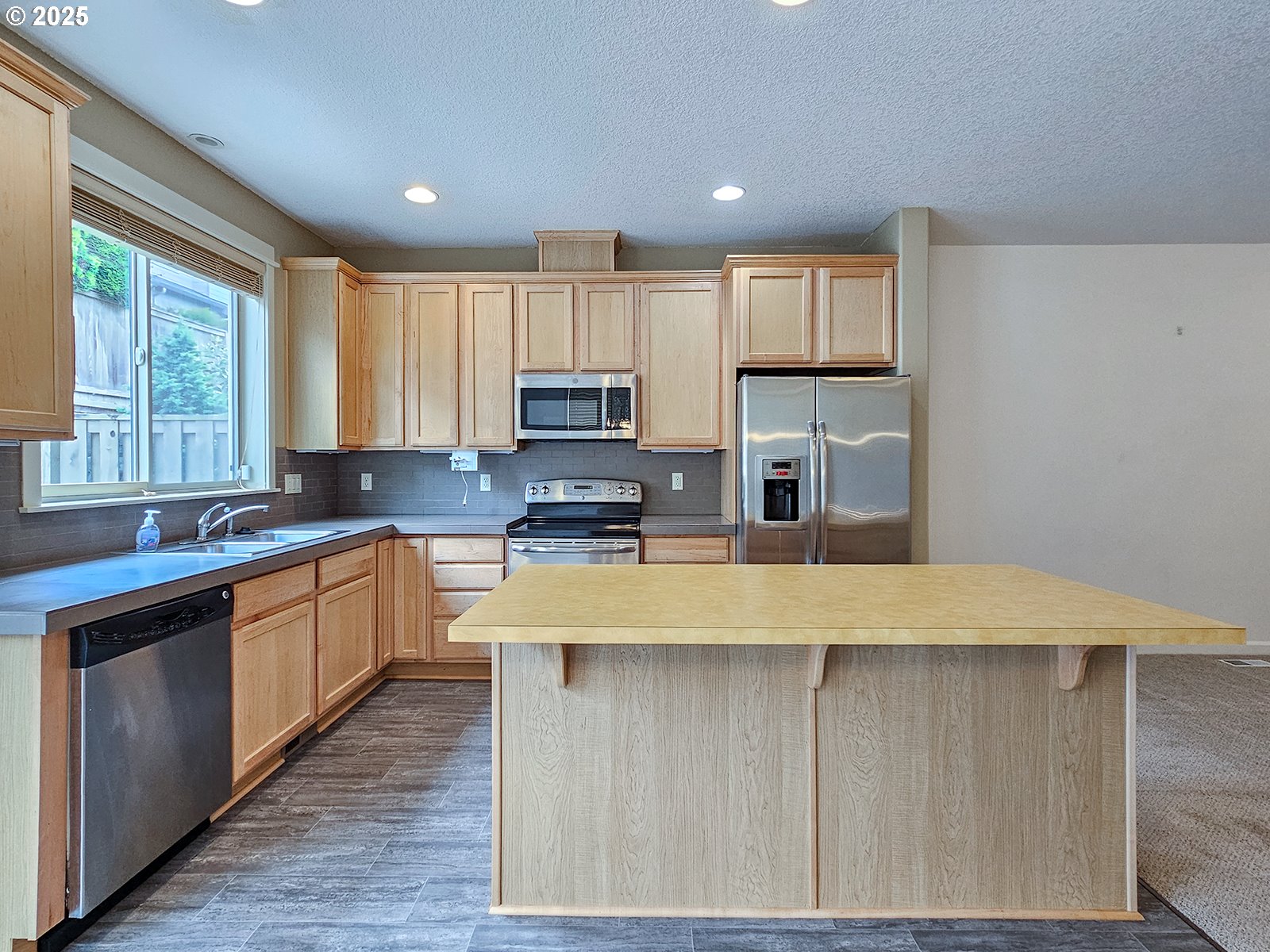 15621 Southeast Eckert Lane Damascus, OR 97089 - Photo 13 of 24 a large kitchen with wooden cabinets and a window