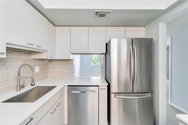 a kitchen with appliances a sink and cabinets