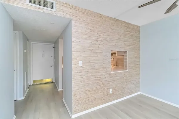 a view of an empty room with closet and a window
