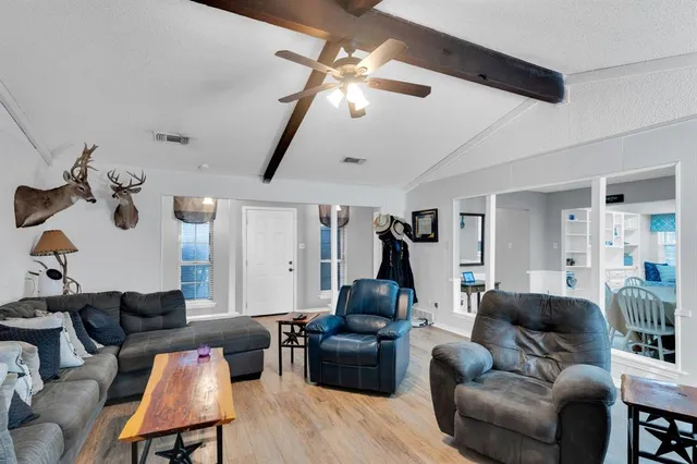 a living room with furniture a ceiling fan and a rug