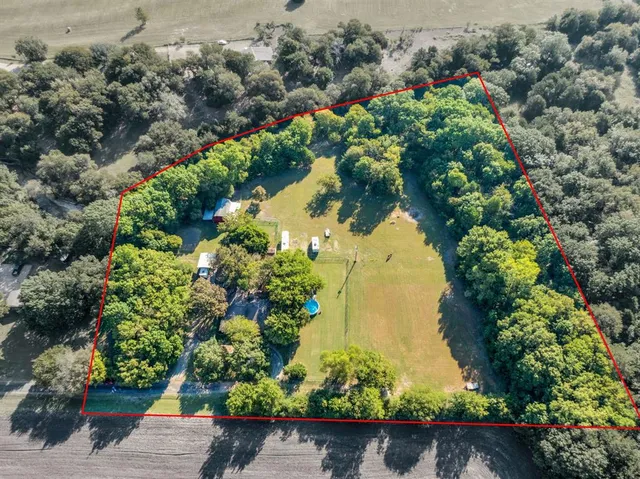 an aerial view of ocean and residential houses with outdoor space