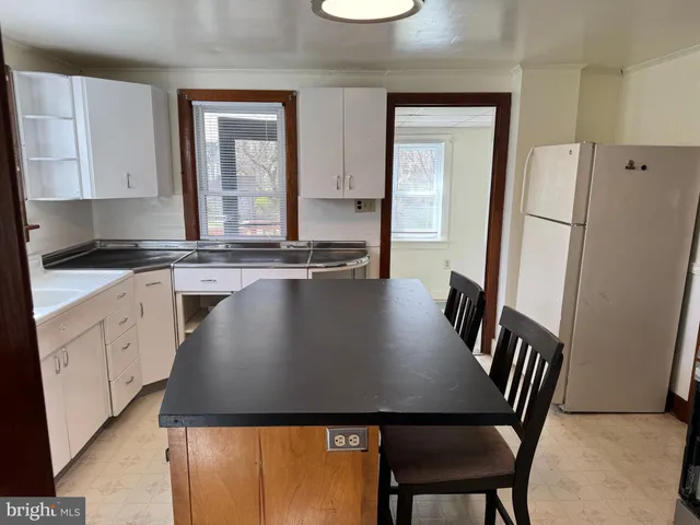 a view of kitchen with cabinets table and chairs