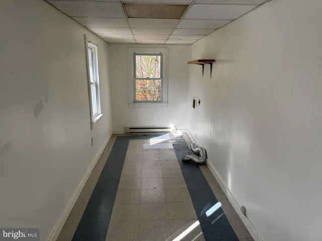a walk in closet with wooden floor