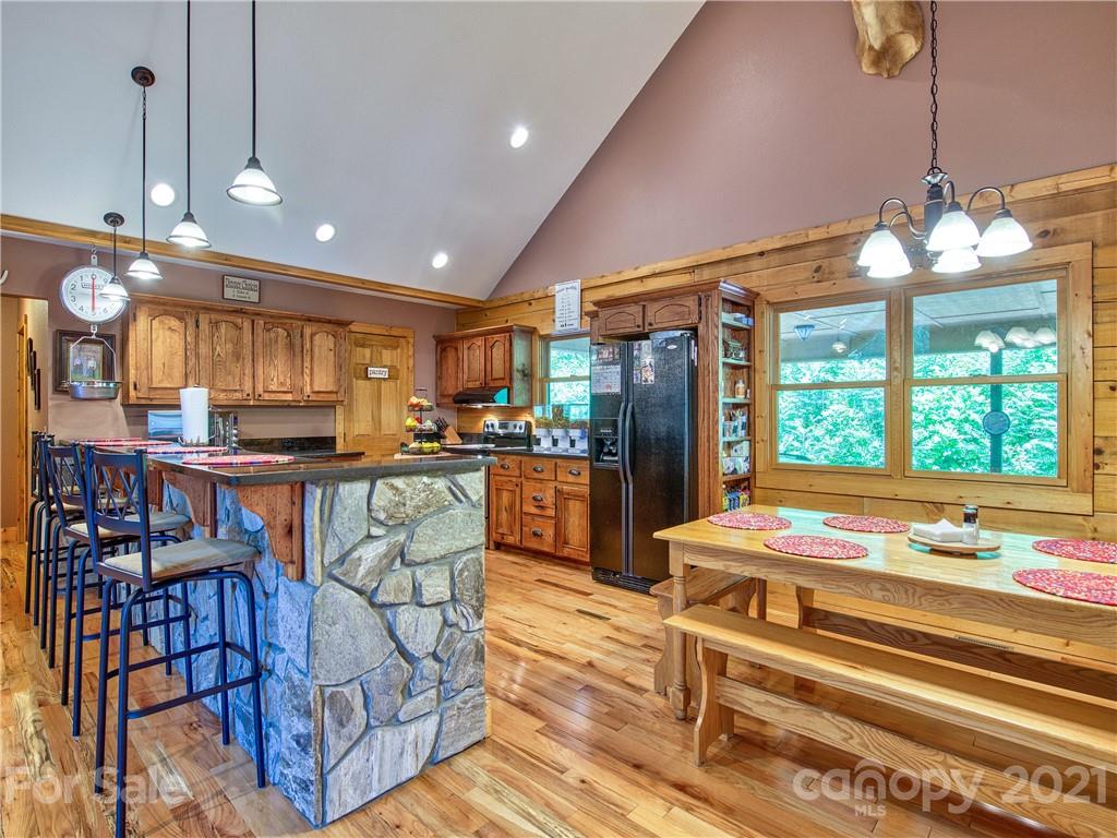 273 Mellow Springs Road Waynesville, NC 28786 - Photo 12 of 40 a kitchen with stainless steel appliances kitchen island granite countertop a refrigerator a stove a sink dishwasher and a dining table with the view of living room