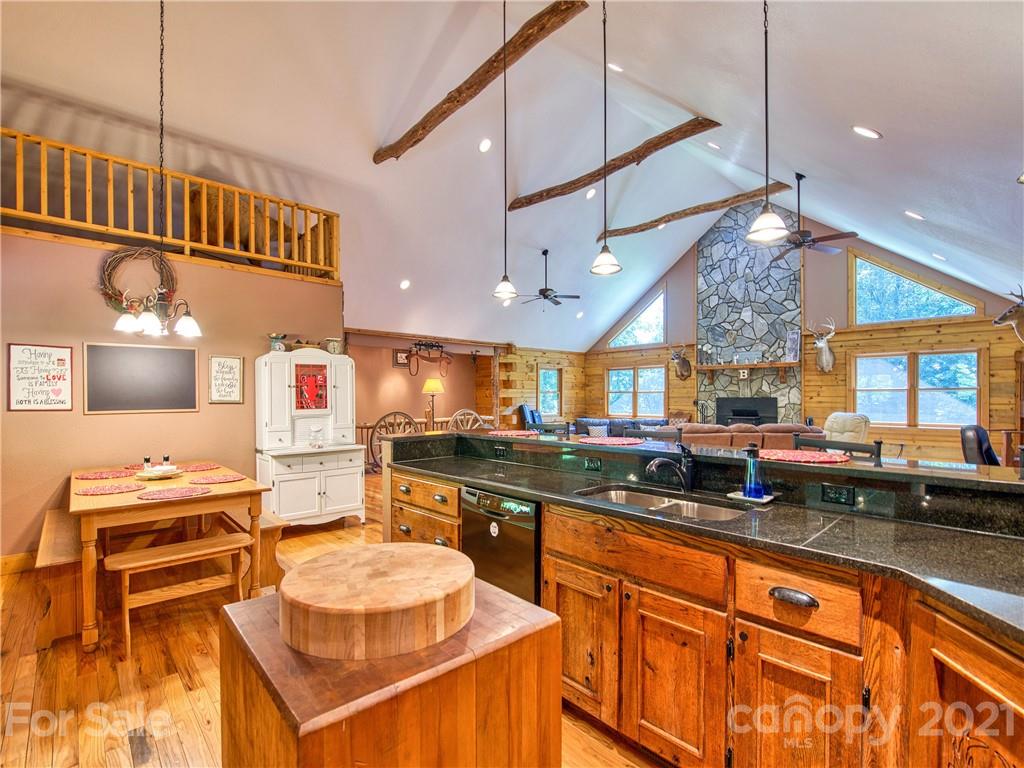 273 Mellow Springs Road Waynesville, NC 28786 - Photo 15 of 40 a kitchen with stainless steel appliances granite countertop a sink a stove and a wooden cabinets