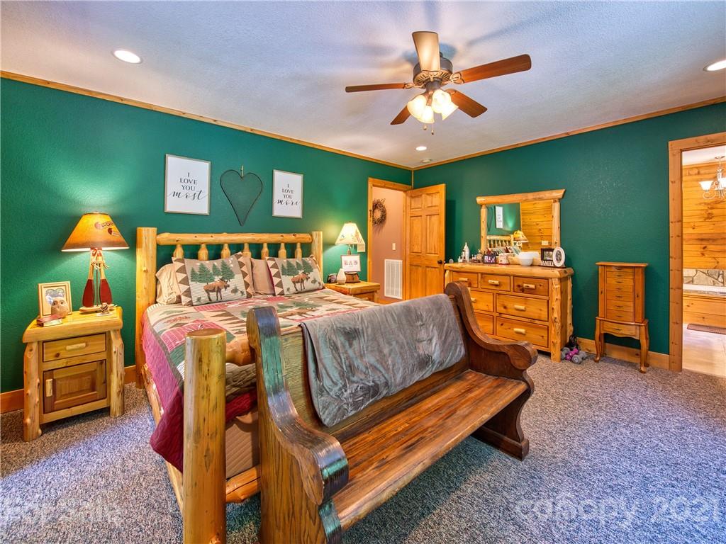 273 Mellow Springs Road Waynesville, NC 28786 - Photo 18 of 40 a bed room with furniture and a chandelier