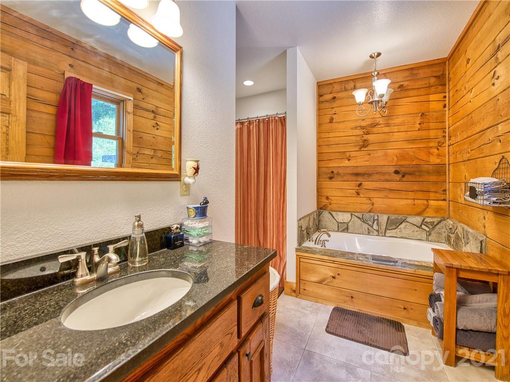 273 Mellow Springs Road Waynesville, NC 28786 - Photo 20 of 40 a bathroom with a granite countertop sink and a mirror