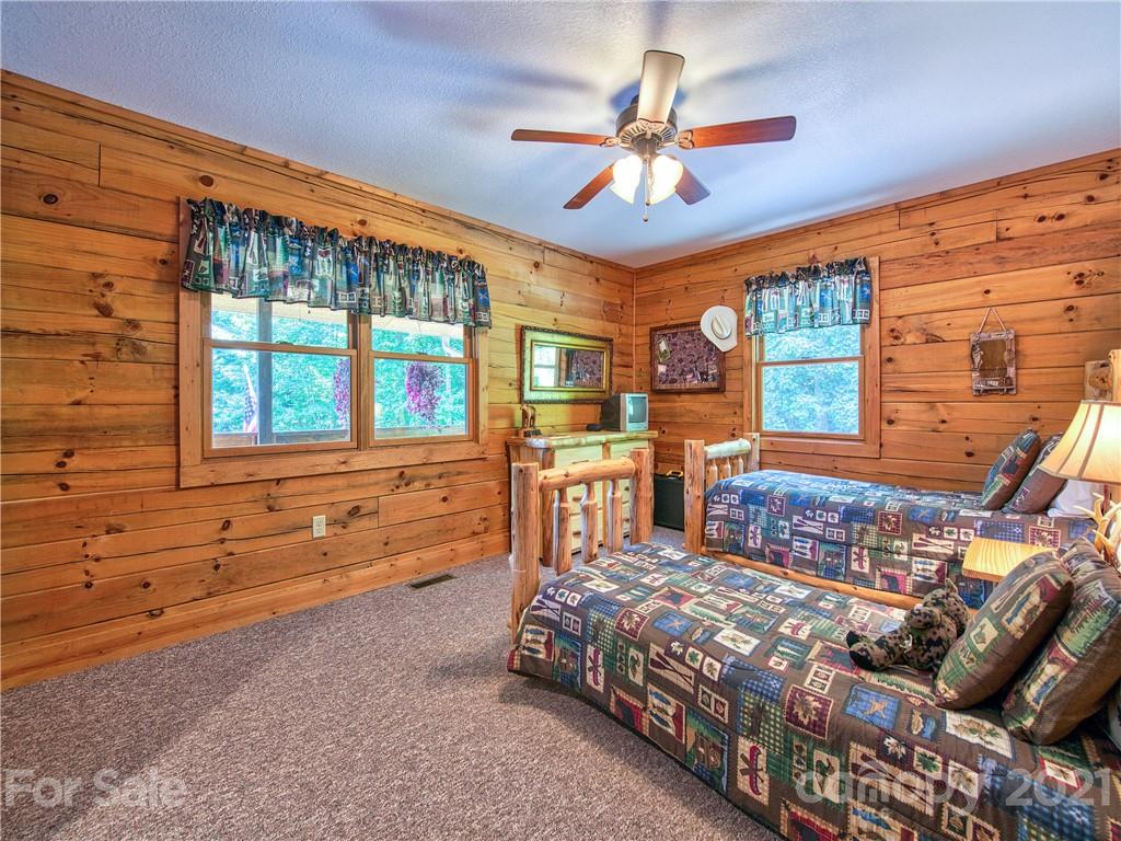 273 Mellow Springs Road Waynesville, NC 28786 - Photo 22 of 40 a bedroom with a large bed and a chandelier