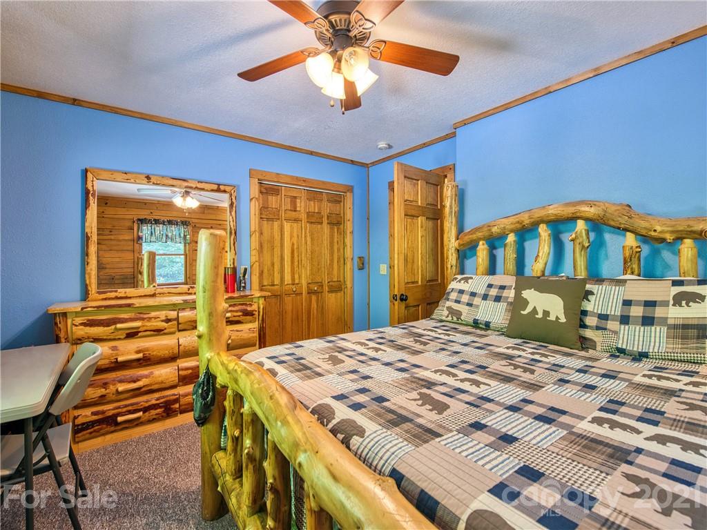 273 Mellow Springs Road Waynesville, NC 28786 - Photo 25 of 40 a bedroom with a bed and a chandelier