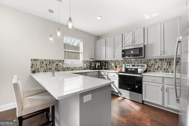 a kitchen with kitchen island white cabinets appliances and window