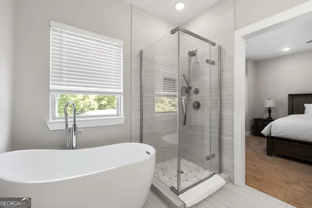 a bathroom with a tub shower and window
