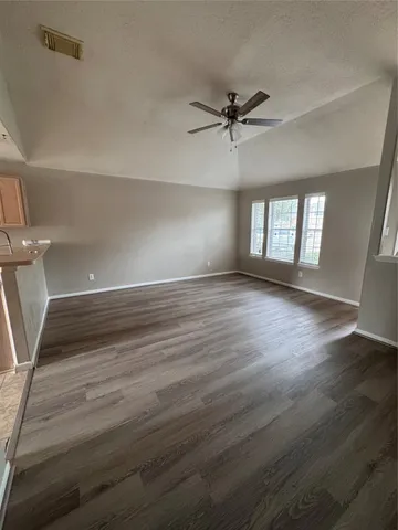 a view of a room with wooden floors and window