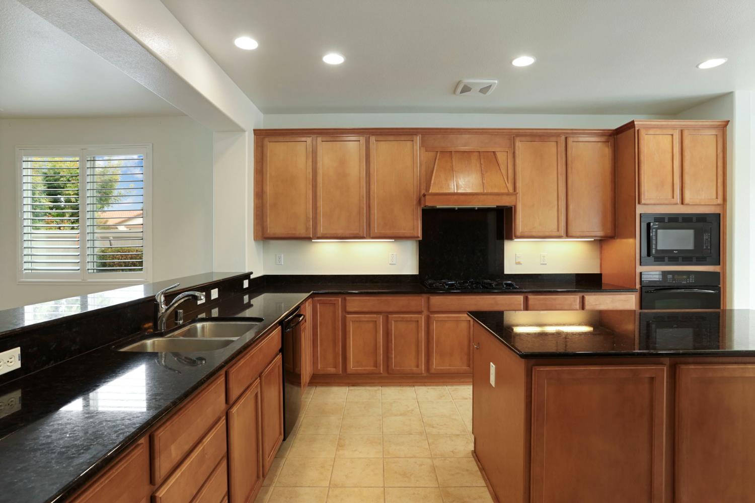 1709 Fox Trot Way Manteca, CA 95336 - Photo 4 of 24 a kitchen with granite countertop a sink and a stove